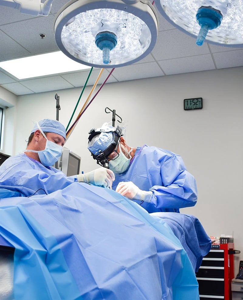 Two surgeons performing surgery in an operating room.